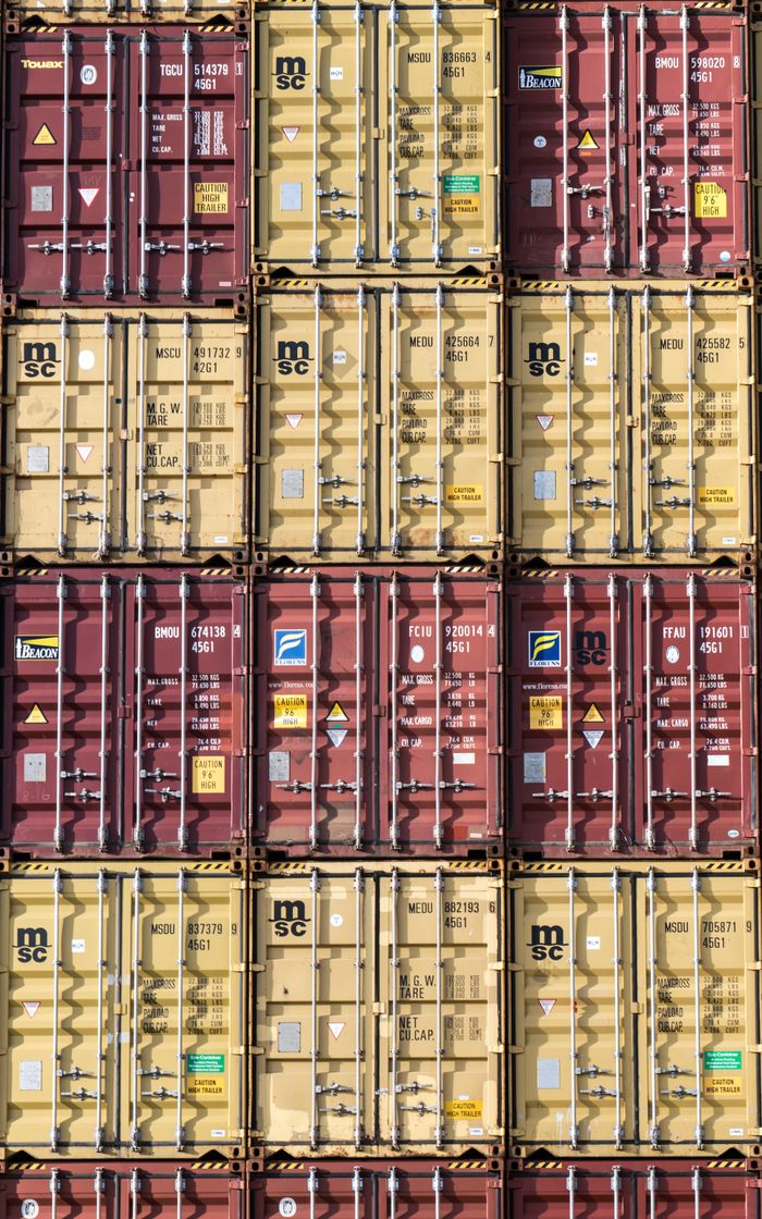 Vertical stack of red and yellow shipping containers, illustrating global logistics.